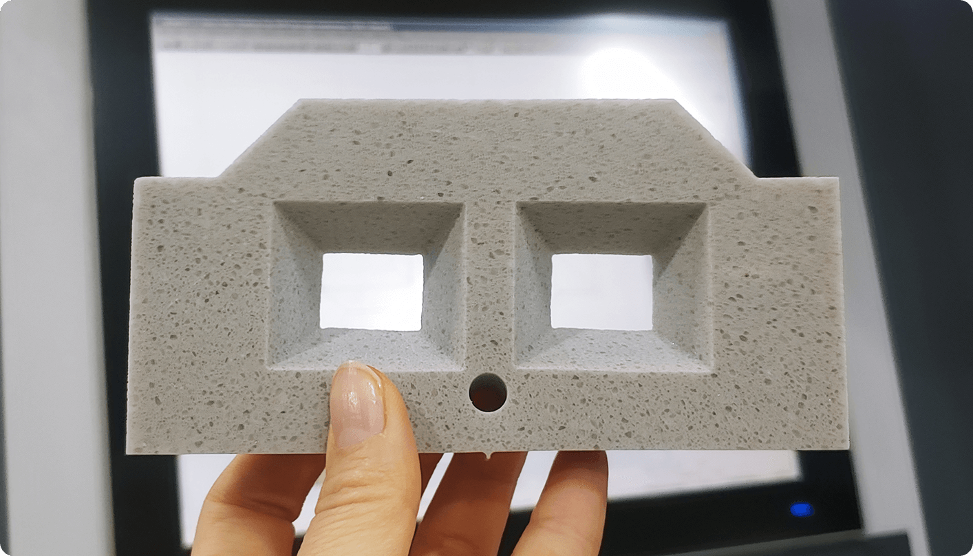 A person holding a beveled sample cut